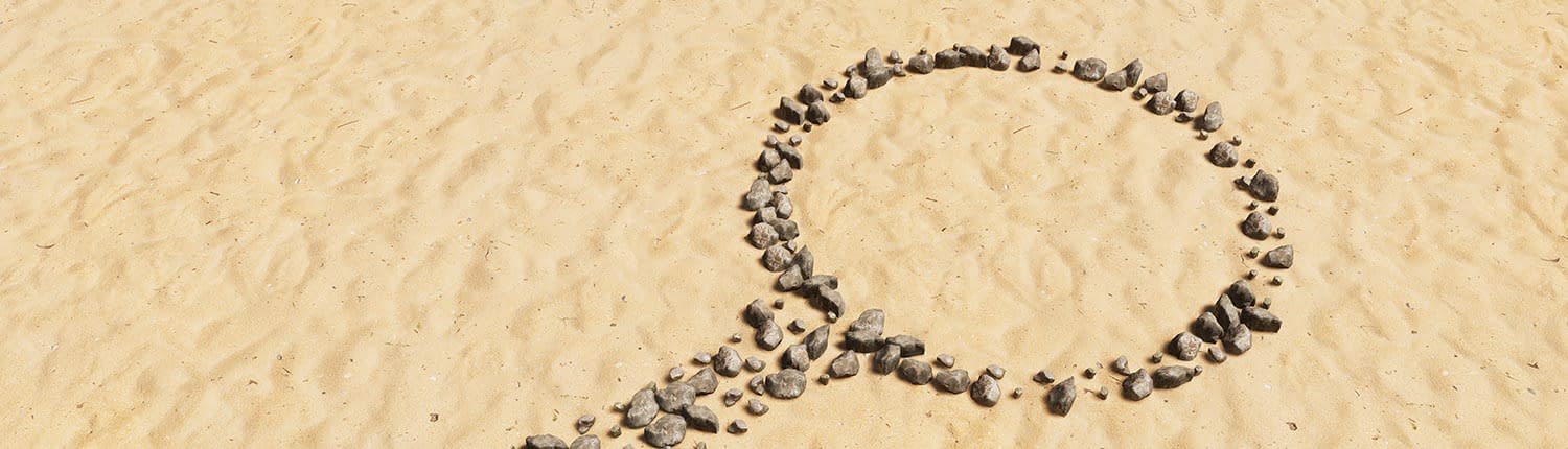 Symbol aus Steinen im Sand