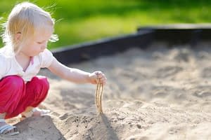 Kind spielt im gereinigten Sand von Sandfuchs