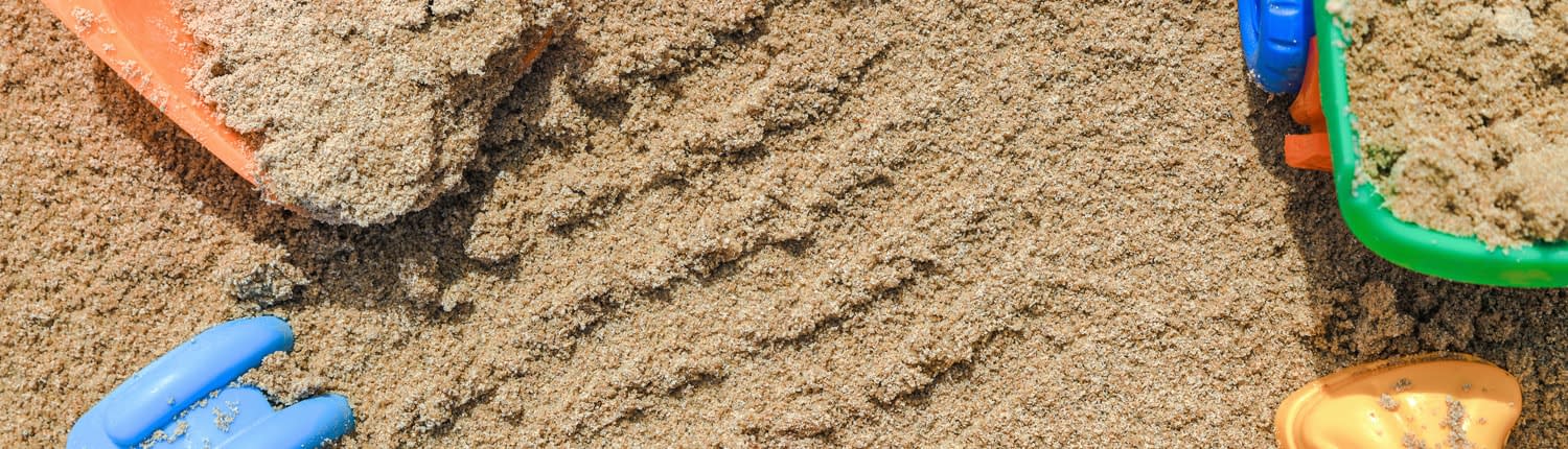 Sandspielzeug in sauberem Sand auf Spielplatz dank Spielsandreinigung