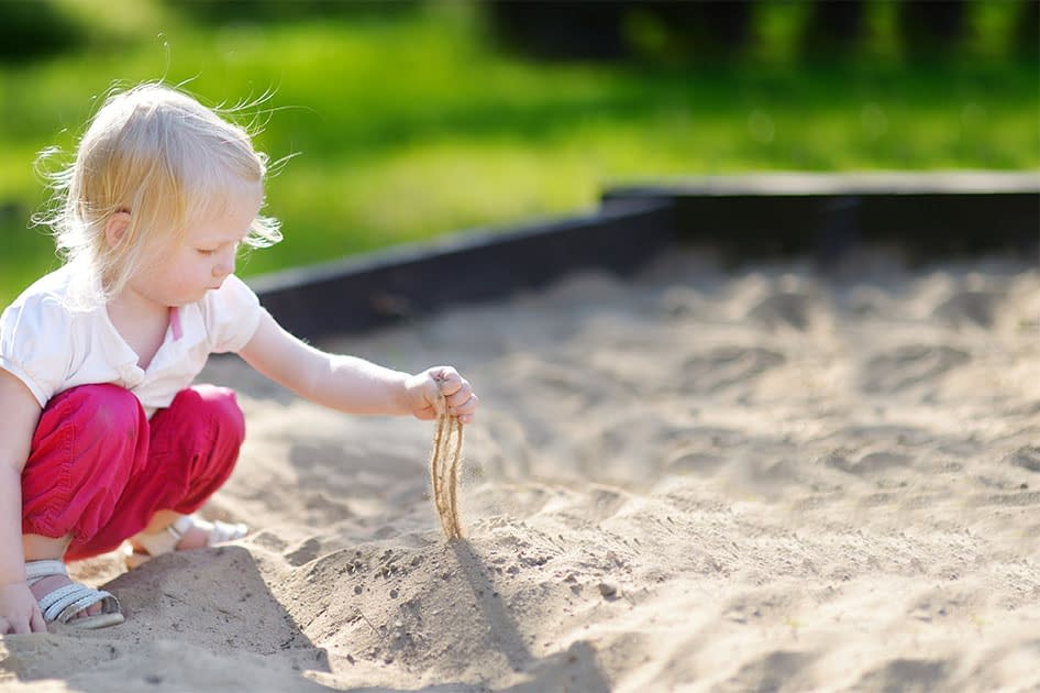 Kind spielt im sauberen Spielplatzsand